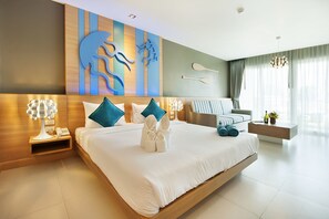 Habitación de hotel moderna con una cama grande, cabecera de madera, una obra de arte colgada en la pared, mesita de noche con lámpara y vista al interior de la habitación.