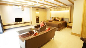 A modern hotel room with a sofa, a bed, a TV, and a desk. - Hua Hin White Sand (Hua Hin)