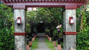 A garden pathway with stone pillars and lanterns, leading to a building entrance. - Hua Hin White Sand (Hua Hin)