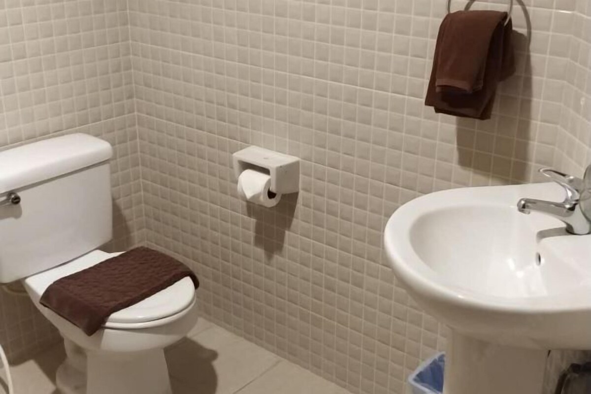 A bathroom with a toilet, a sink, and a towel rack.