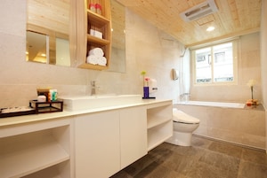 Un baño moderno con un tocador blanco, un inodoro y una bañera.