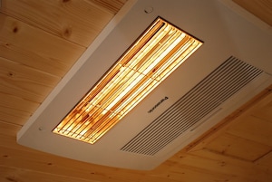 Un techo con un panel de calefacción radiante y una rejilla de ventilación.