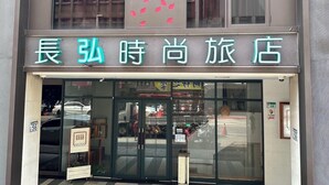 A hotel entrance with a neon sign in a foreign language, a glass door, and a visible street view outside. - Nagahiro Hotel (Taipei)