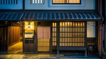 A traditional Japanese building with a wooden entrance, sliding doors, and a tiled roof.