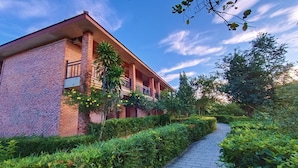 A brick building with a covered walkway and lush greenery. - Hue Riverside Boutique Resort & Spa (Hue)