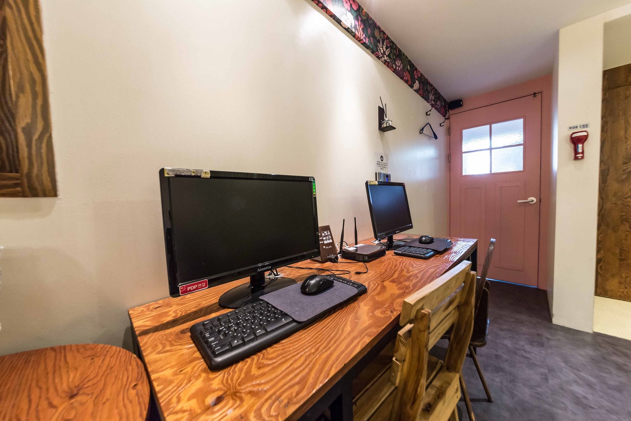 Un escritorio de madera con dos monitores, un teclado y un ratón.