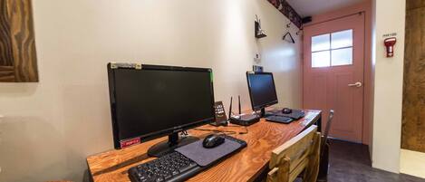 Un escritorio de madera con dos monitores, un teclado y un ratón.
