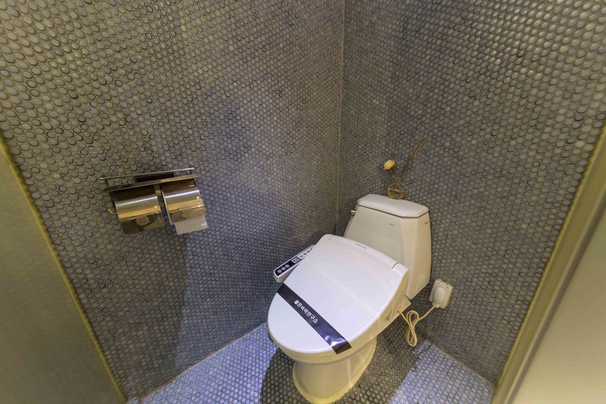 Un baño pequeño y moderno con inodoro, bidé y secador de manos.