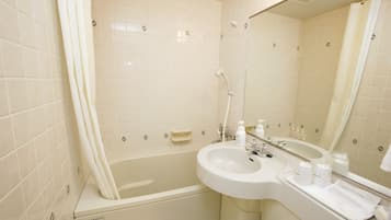 Un baño con bañera, lavamanos y espejo.