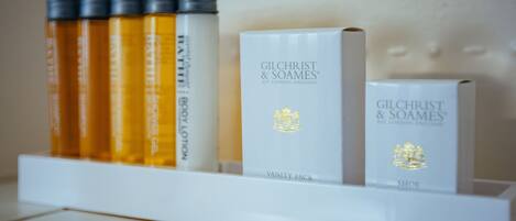 Uno scaffale con diversi prodotti Gilchrist & Soames, tra cui un kit da bagno e una scatola per scarpe.