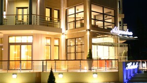 A hotel with a modern facade, large windows, and a prominent sign. - Alexandros Boutique Hotel (Argos-Mykines)