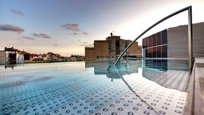 Una piscina en la azotea con vista despejada del paisaje urbano.