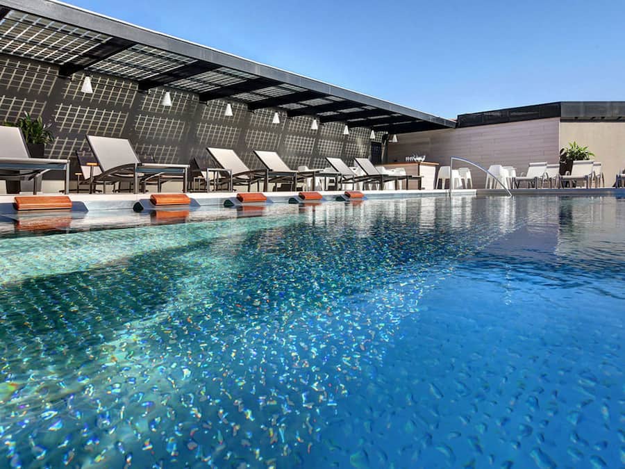 Una piscina al aire libre, sillones reclinables de piscina