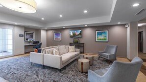 A spacious living area with a sofa, armchairs, and a coffee table. - Candlewood Suites Greenville by IHG (Greenville)