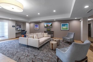 Un amplio espacio de sala con un sofá, sillones y una mesa de centro.