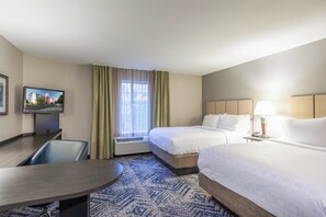 A hotel room with a bed, a desk, a chair, a TV, and a window with curtains. - Candlewood Suites Greenville by IHG (Greenville)