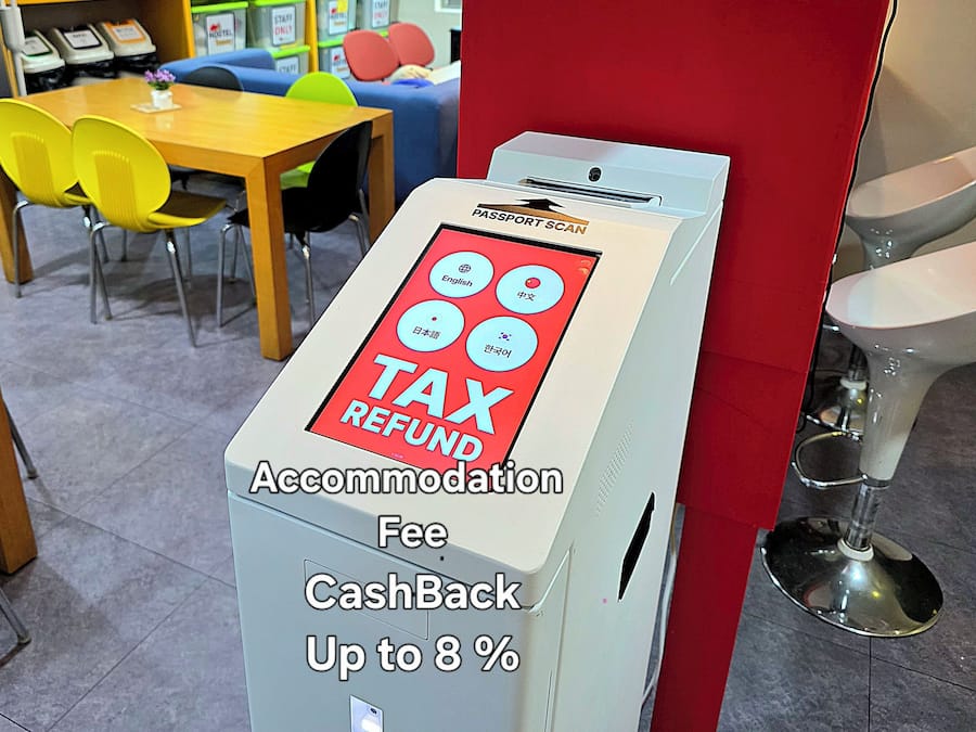 A TAX REFUND machine in a hostel with a sign indicating a fee and a CashBack up to 8%.