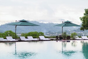 Una piscina al aire libre, sombrillas, tumbonas
