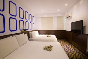 A hotel room with two beds, a flat-screen TV, and a wall with geometric blue designs. - Ximen Holiday Fun Hotel (Taipei)