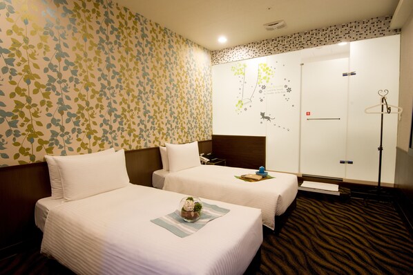 Habitación de hotel con dos camas, un mapa en la pared y un perchero.