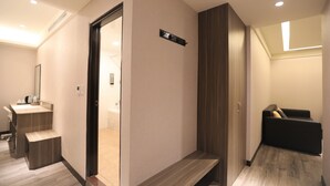 Quarto de hotel moderno com um banco de madeira, uma pequena escrivaninha e um banco embutido na parede.