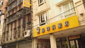 A hotel with a yellow signboard, multiple floors, and balconies. - Golden Hotel (New Taipei City)