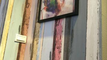 A wall with a colorful, distressed paint finish and a framed artwork.