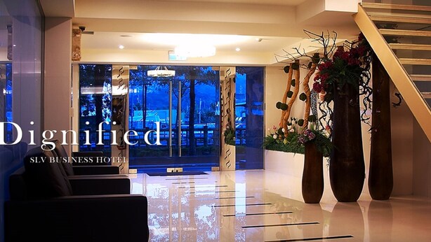 A modern hotel lobby with a reception desk, seating area, and a staircase. - SLV Hotel Group - SLV Business Hotel (New Taipei City)