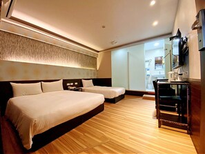 A hotel room with two beds, a wooden floor, a TV, and a small table. - Hotel 6 - Ximen (Taipei)