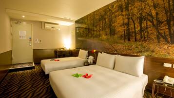Habitación de hotel con dos camas, un cuadro de un bosque en la pared, un escritorio con una lámpara y un teléfono sobre una mesita.