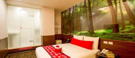 Una habitación de hotel con una cama, una mesita de noche, un teléfono, un espejo y una pared con un mural de un bosque.