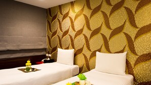 A hotel room with two beds, a patterned wall, and a small table with a lantern and a tray of items. - Hotel 6 - Wannien (Taipei)