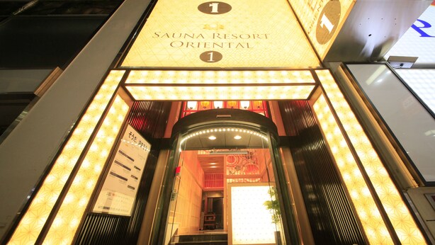 The entrance to Sauna Resort Oriental with illuminated signage and a red carpet.