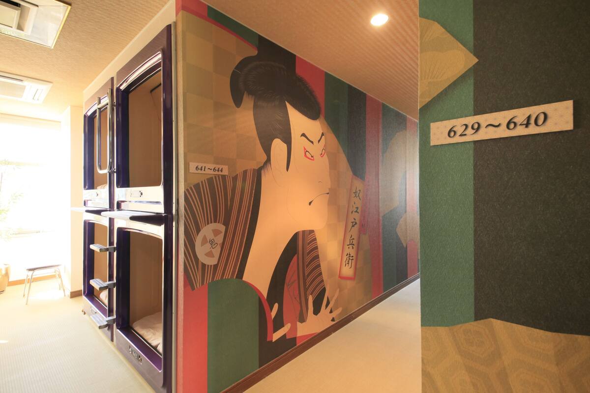 A room with bunk beds, a wall with a number sign, and a large mural.