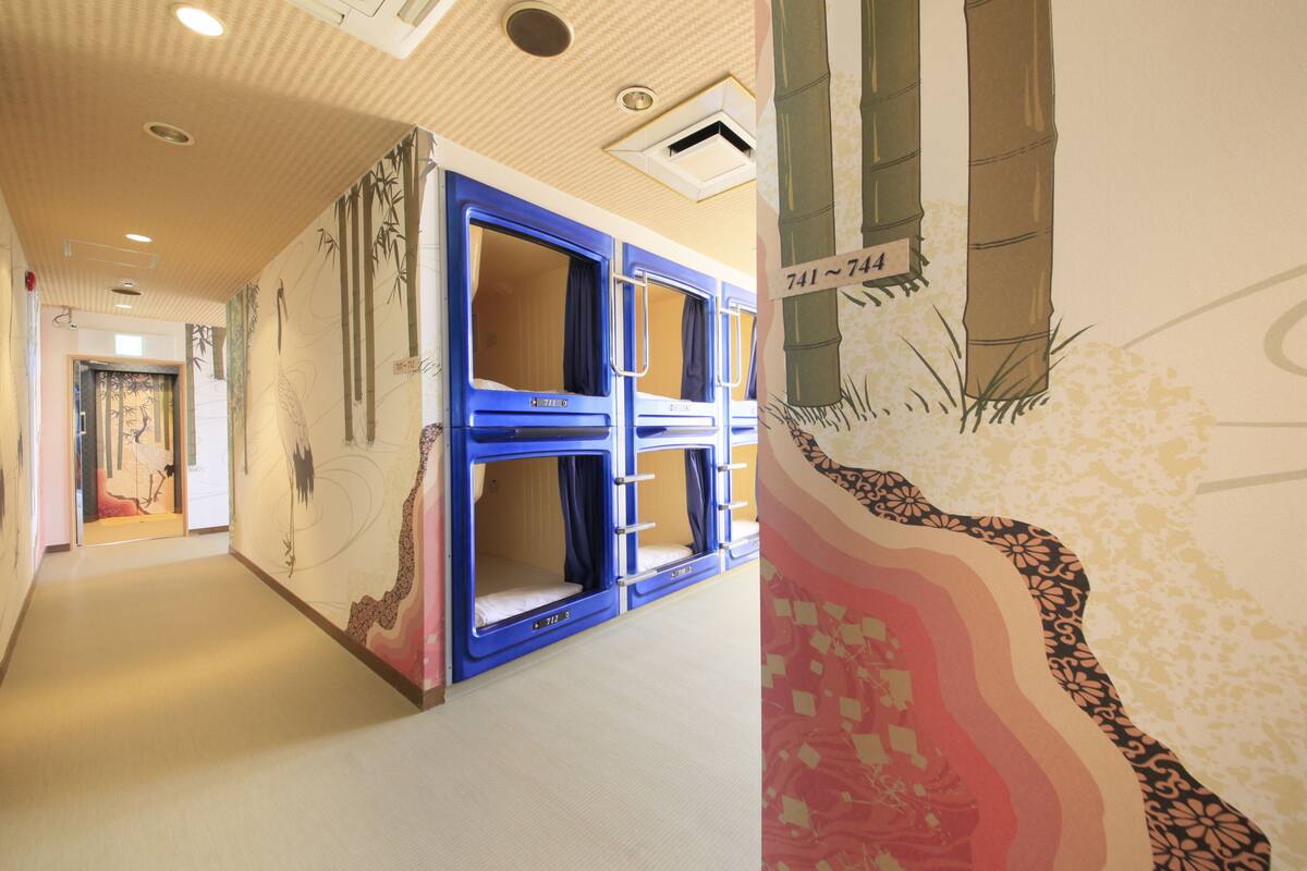 A corridor with bunk beds and a mural on the wall.