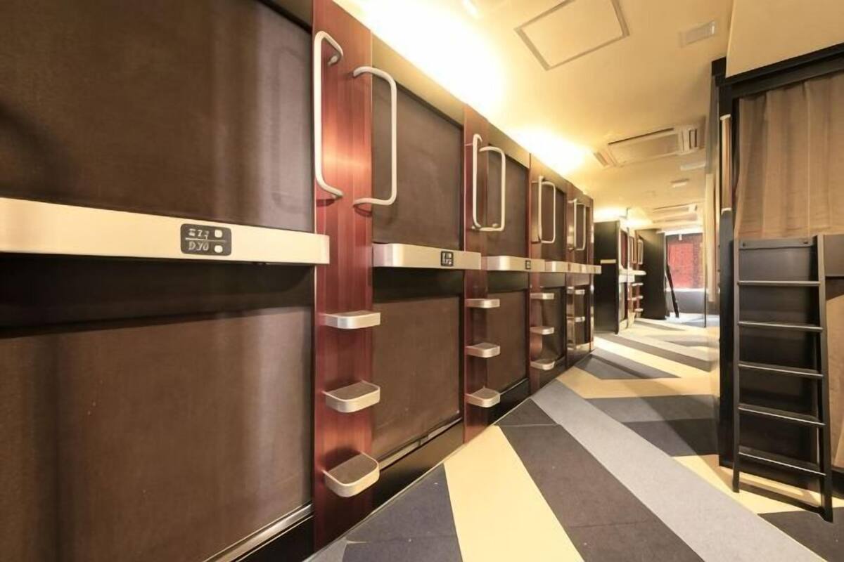 A row of hotel rooms with wooden doors, metal handles, and a check-in counter.