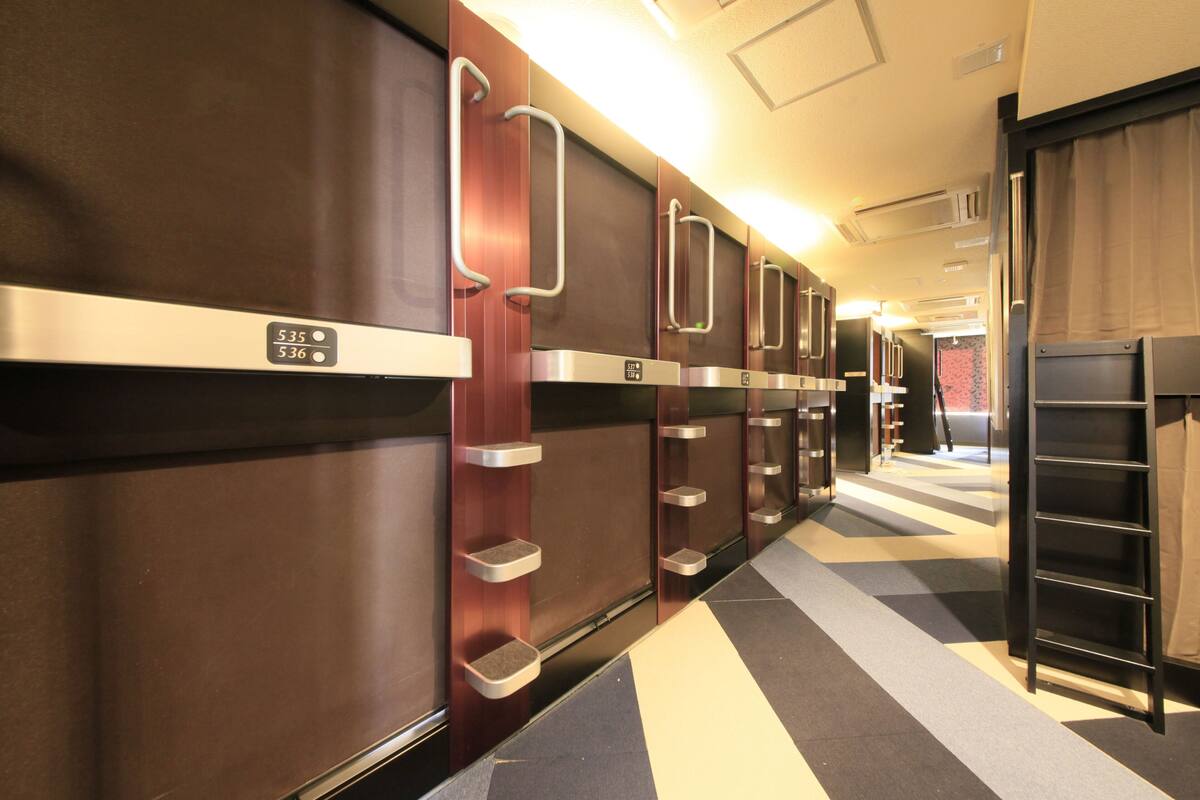 A hotel corridor with multiple rooms, each with a door and a small shelf.