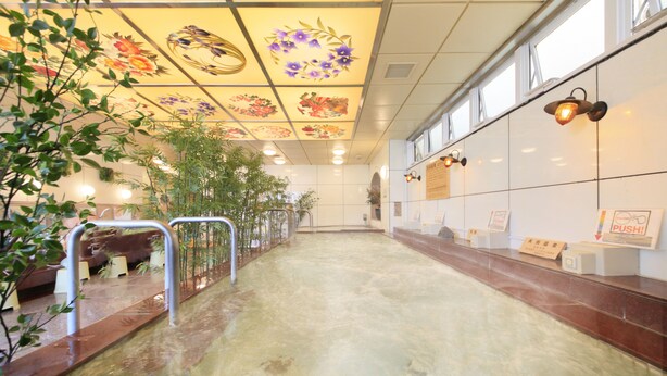 A hallway with a tiled floor, metal railings, and a ceiling with floral designs. There are signs on the wall and a bench along the left side. - UENO STATION HOSTEL ORIENTAL 2 - Cater to Men (Tokyo)