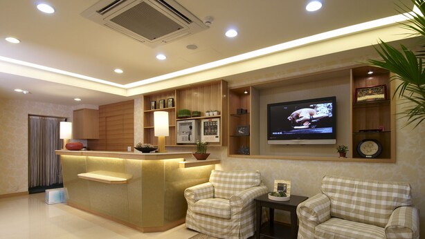 A modern living room with a central island, two armchairs, a television, and a plant. - Hotel Color (New Taipei City)