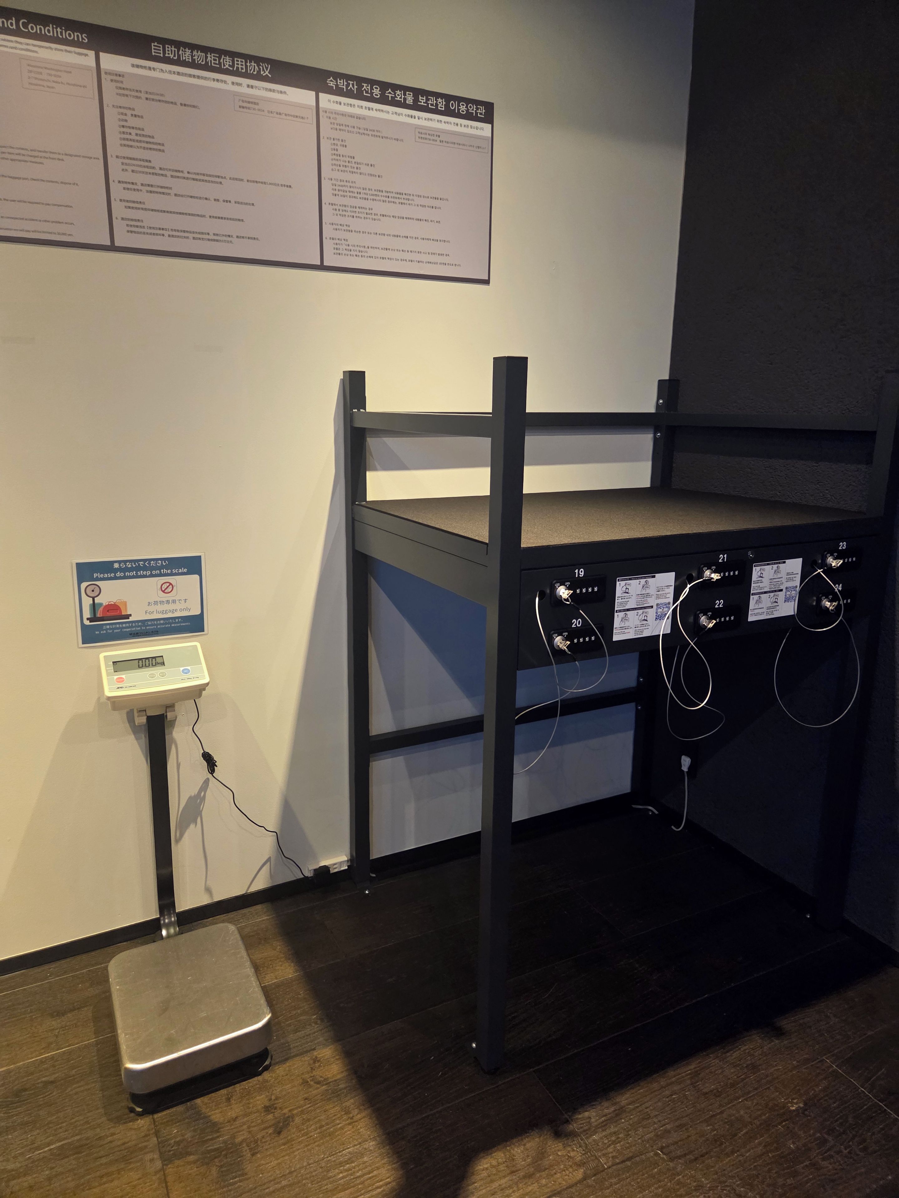 A bunk bed with a luggage scale and a wall-mounted sign.