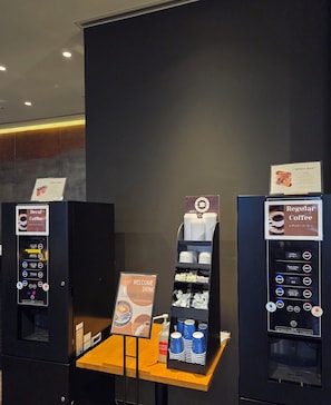 A coffee vending area with two machines, one for decaf and one for regular coffee, and a display of disposable cups. - Hiroshima Washington Hotel (Hiroshima)