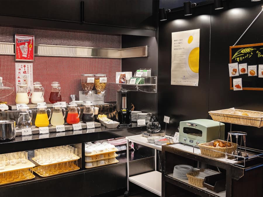 A breakfast bar with various food and drink options, including coffee and tea.