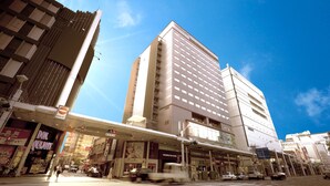 A multi-story building with a prominent 'Washington Hotel' sign, a pedestrian overpass, and a crosswalk. - Hiroshima Washington Hotel (Hiroshima)