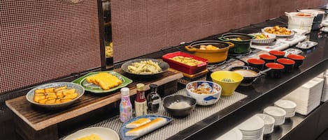 A buffet with various dishes and condiments.