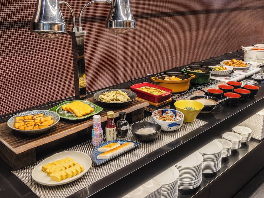 A buffet with various dishes and condiments.