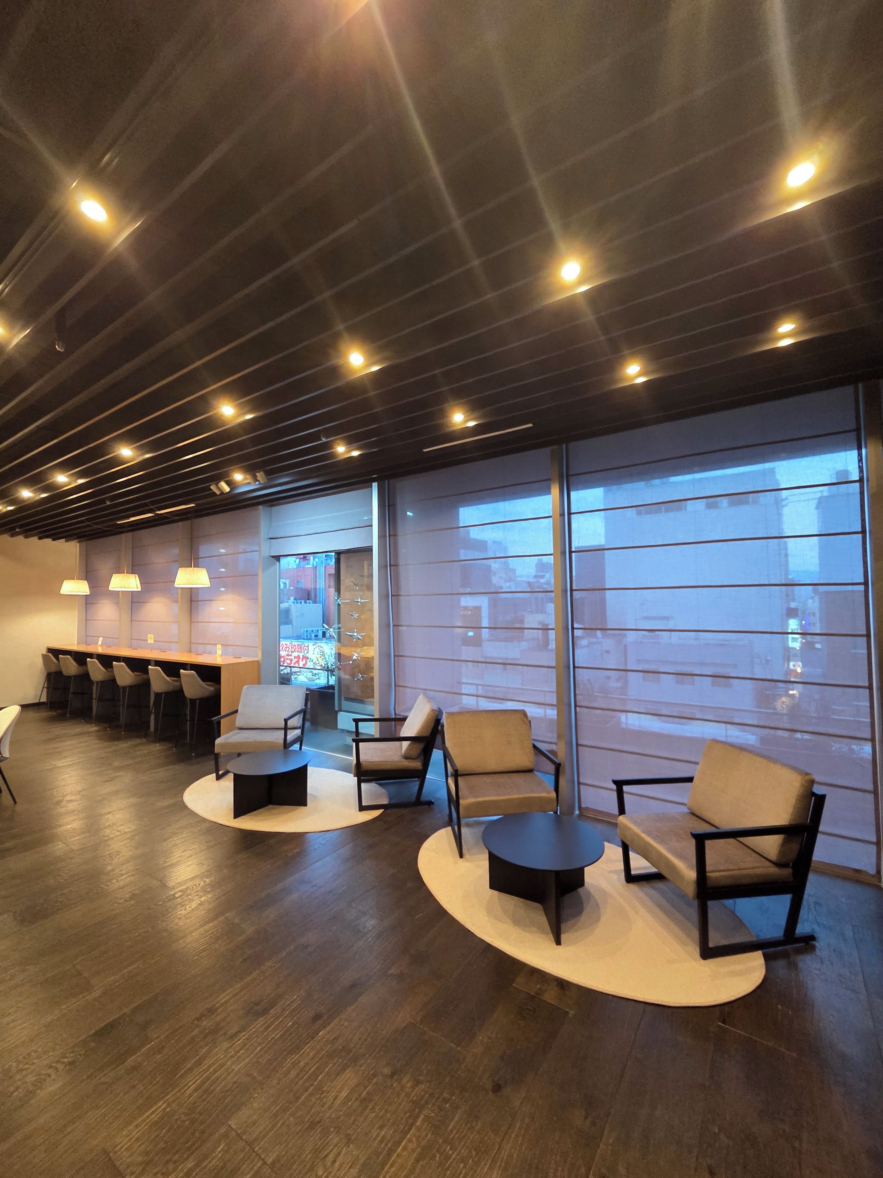 Un interior moderno con una zona de bar, asientos y ventanas amplias.