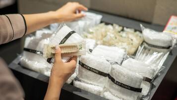 Exhibición de toallas corporales con un cartel que dice 'BODY TOWEL' en una tienda.