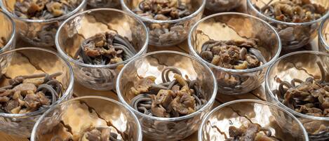 Multiple clear glass bowls filled with a dish containing noodles and meat.