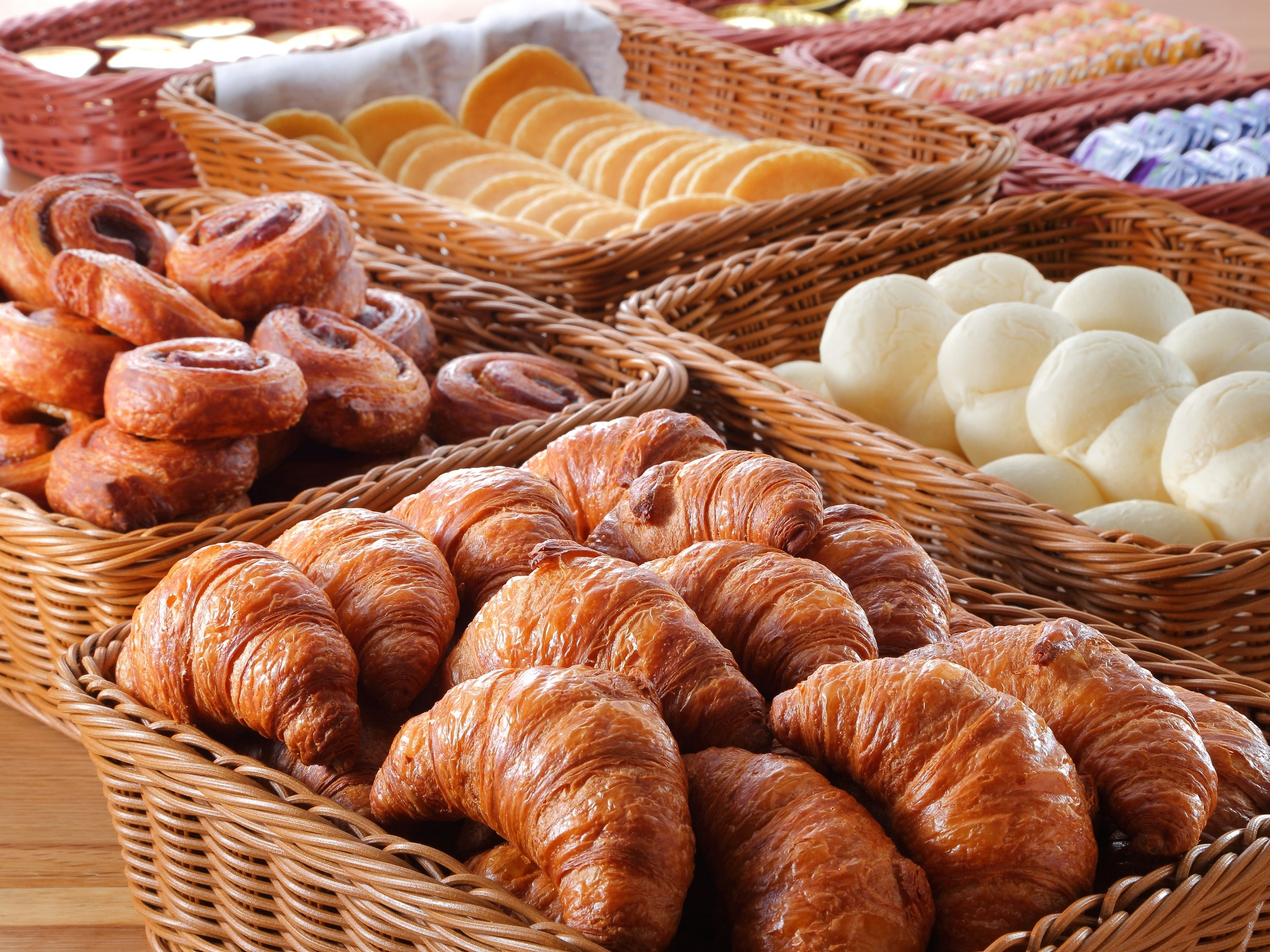 A variety of baked goods displayed in wicker baskets.
