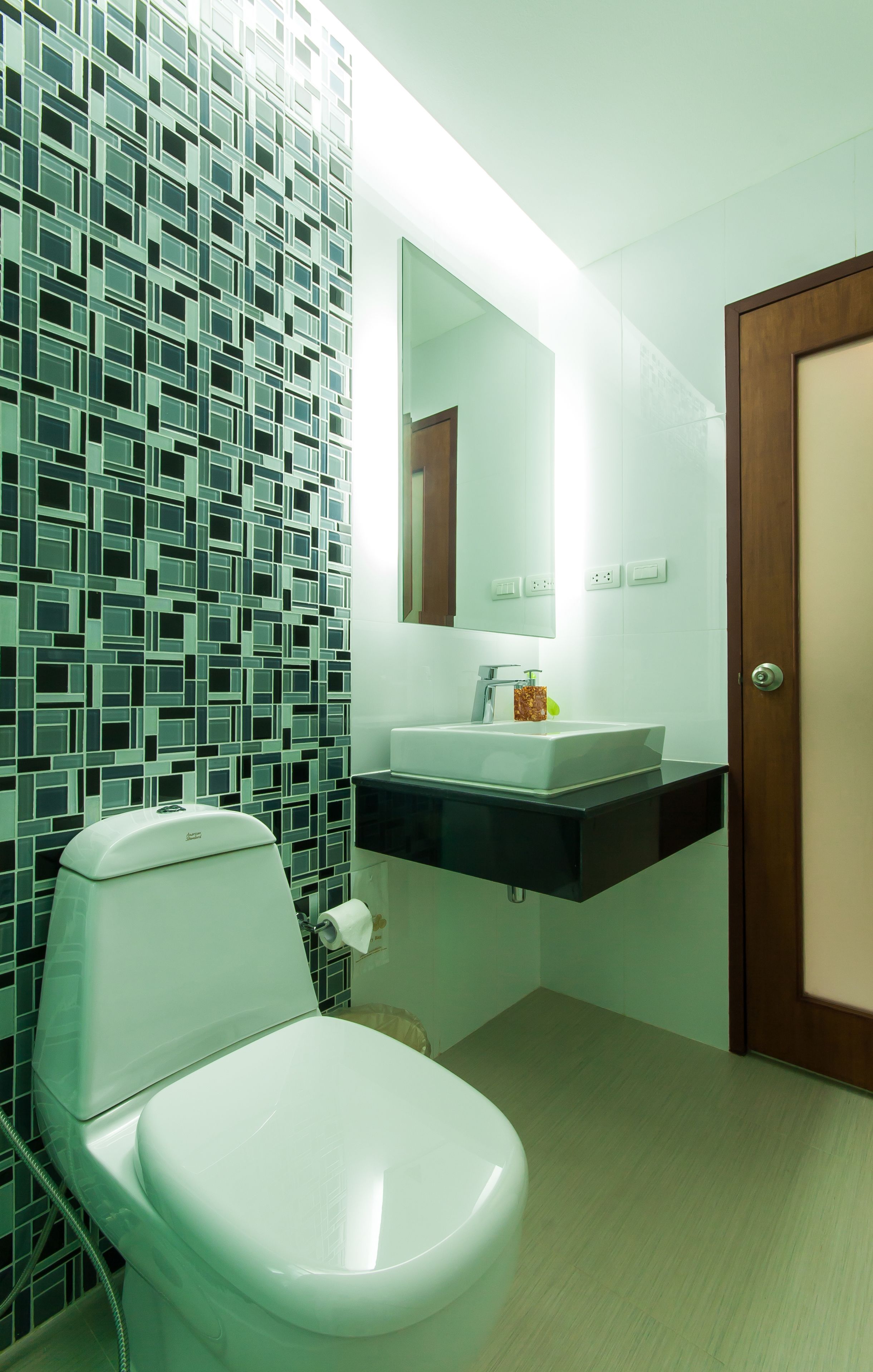 Une salle de bain moderne avec des toilettes, un lavabo et un miroir.